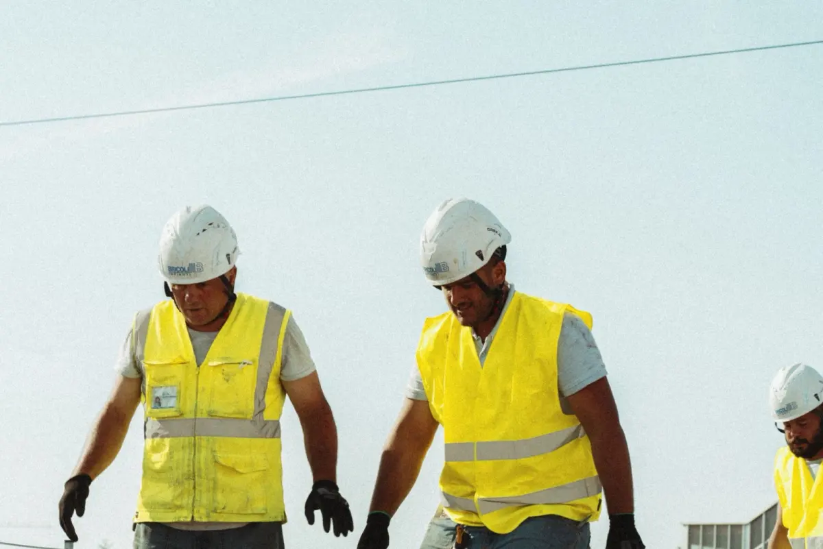 Due tecnici Bricoli con elmetto e gilet ad alta visibilità al lavoro in cantiere